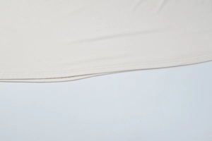 Detail of high-quality hem stitching on this cream-colored V-neck lace dress fabric