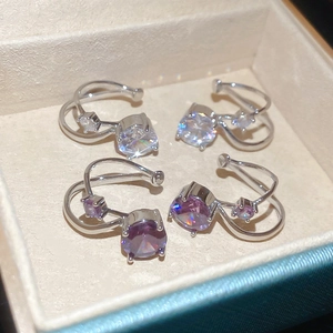 Detail view of silver and purple double-layer cubic zirconia ear cuffs in a jewelry box