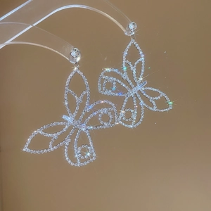 Detail of silver butterfly pendant earrings with micro-pave cubic zirconia crystals
