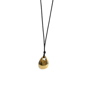 Minimalist gold titanium bean pendant necklace with black cord on white background