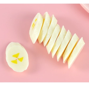 Detailed macro view of realistic PVC banana slice charm with cream and yellow core texture