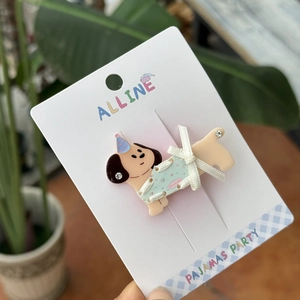 Detail of cartoon dog hair clip with spring day text on white brand card background