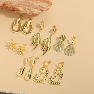 Golden earring set with heart, leaf, and geometric designs in polished metal finish