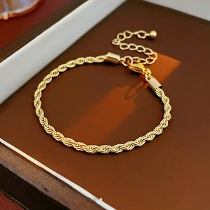 Close-up of golden twist rope chain bracelet with lobster clasp and extension chain