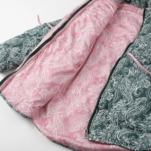 Detailed view of quilted cotton jacket with green paisley pattern and pink lining