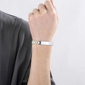 Close-up of a two-tone stainless steel adjustable bracelet worn on a wrist