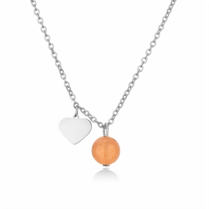 Close-up of heart charm and orange natural stone pendant on stainless steel chain