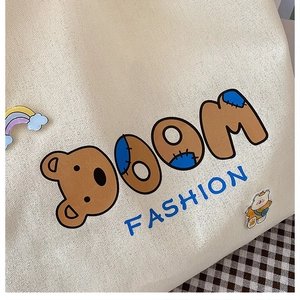 Detail der Canvas-Einkaufstasche mit Cartoon-Bär-Aufdruck und Mode-Textur-Muster