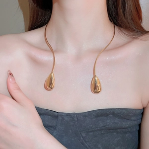 Close-up of golden teardrop choker necklace on model showcasing elegant metallic finish