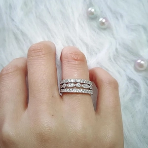 Détail de bagues superposées en argent avec des zircons marquise et ronds brillants