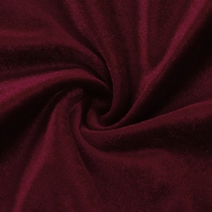 Close-up of deep wine red velvet fabric with elegant shirred texture and glossy finish