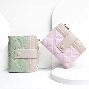 Detail of mint green and pale pink quilted PU leather wallets with beige snap closures