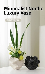 Detail of artistic irregular white ceramic vase with matte petal texture and greenery