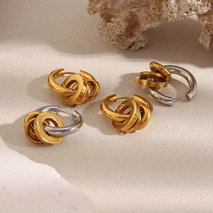 Vue détaillée de boucles d'oreilles créoles triples plaquées or 18K sur fond de pierre