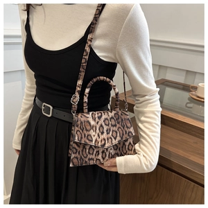 Detail showing leopard print texture and metal buckle on the stylish flap crossbody bag