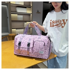 Detailed view of a purple leopard print travel bag held by a person in a room