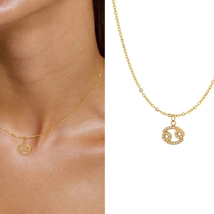 Detailed view of Cancer zodiac pendant with micro-pave crystals on gold necklace