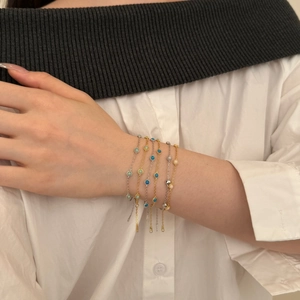 Close-up of stacked S925 silver bracelets with turquoise and white beads on a wrist