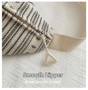 Detailed macro view of smooth silver metal zipper and triangle puller on corduroy bag