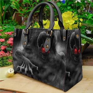 Gothic black PU leather handbag with red-eyed skull print in outdoor garden setting