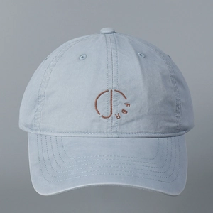 Close-up of light blue cotton baseball cap featuring brown circular FBR letter embroidery