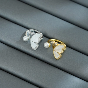 Détail de bagues papillon avec ailes en nacre, perles et diamants en or et argent
