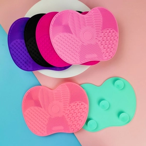 Detailed view of apple-shaped silicone cleaning mats with suction cups and textures