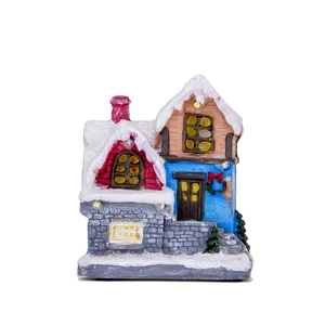 Close-up of hand-painted LED Christmas miniature house with snowy roof and festive lights