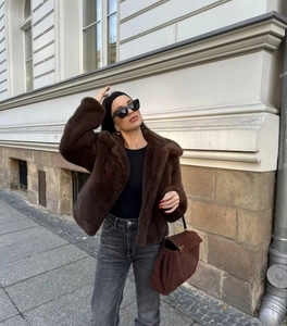Close-up of fluffy brown faux fur jacket texture and large collar details on model