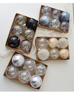 Dettaglio di quattro palline di Natale da 8cm con decorazioni varie in una scatola