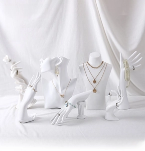 Macro detail of matte white resin portrait and hand jewelry display stands for necklaces