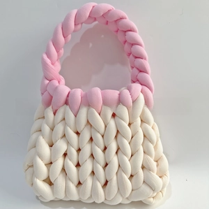 Detail of handmade thick rope knit handbag in cream white with pink woven handles
