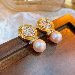 Detail of vintage gold coin earrings with silver relief portraits and white pearl drops