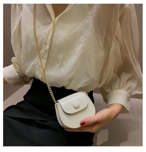 Détail du mini sac selle blanc cassé avec bandoulière chaîne dorée et boucle
