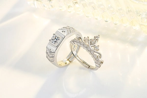 Close-up of S925 silver couple rings featuring crown design and V-shaped geometric band