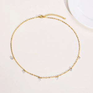 Detail of 18K gold plated necklace with delicate clear zircon teardrop pendants on chain