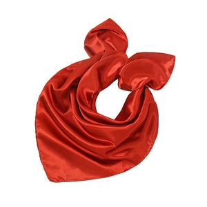 Detail of red satin square scarf showing smooth silk texture and fine stitched edges