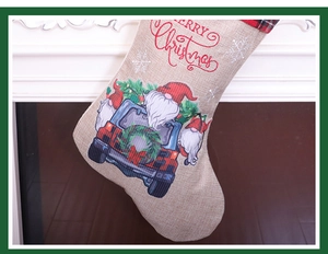 Detail of burlap Christmas stocking with gnome red truck print and plaid cuff on mantel