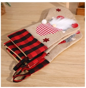 Close-up of linen Christmas stockings with gnome motifs and plaid patterns on wood