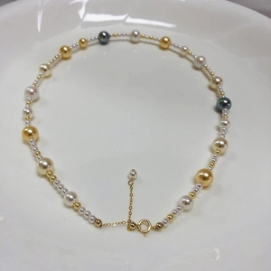 Detail view of multicolored crystal pearls and gold beads on an adjustable necklace