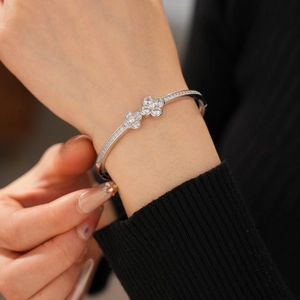 Detailed view of lucky clover zircon bracelet with silver finish on a model's wrist