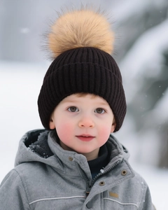 Detailed close-up of dark brown ribbed knit beanie with a fluffy faux fur pom-pom