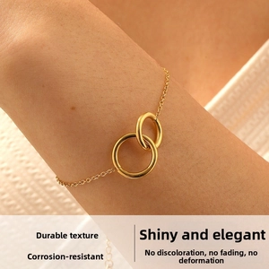 Detail view of gold double interlocking circles on a sleek stainless steel chain