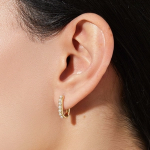U-shaped 18K gold earrings with pearls on earlobe shown from a close-up side angle