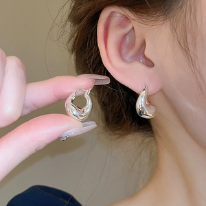 Close-up of polished silver multilayer layered loop earrings showing shiny metallic finish