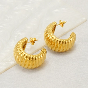 Elegant gold-tone C-shaped stainless steel earrings displayed on a white textured board