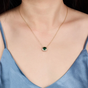 Detail of 925 silver gold necklace with green oval zircon on model neckline