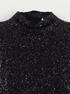 Detail of high neck black sequin top featuring a concealed back zipper and texture