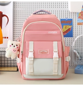 Schulrucksack in Rosa und Weiß mit Schnallenklappe und Plüschbär-Anhänger im Detail