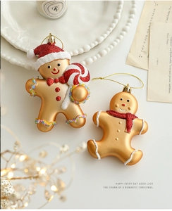 Detail of matte gold gingerbread man ornaments with red glitter accents for Christmas decor